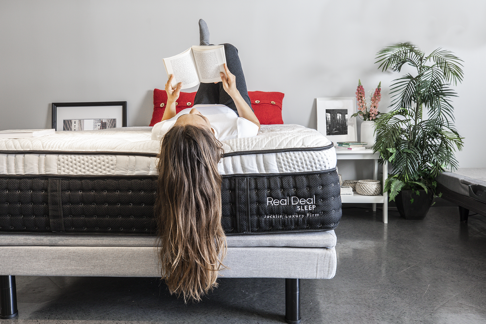 Woman reading a book while laying on Jacklin Luxury Firm bed